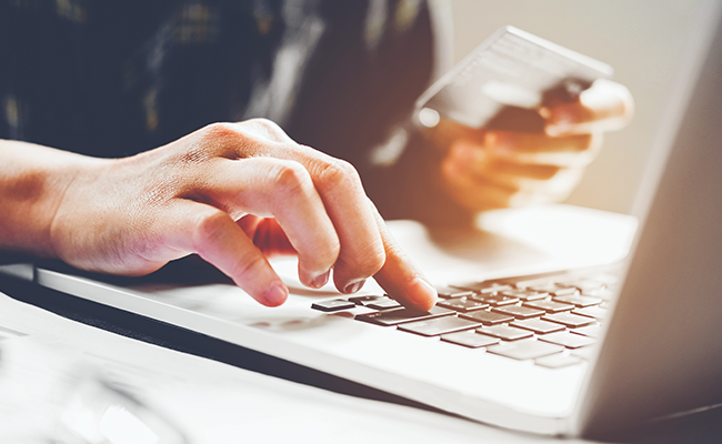 hands holding a credit card on a laptop